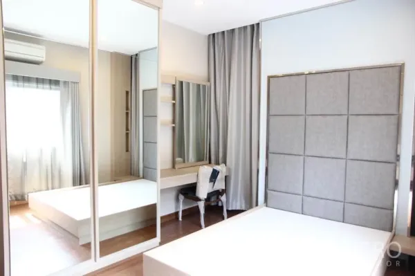 บ้าน ให้เช่าในBang Na, Bangkok - ห้องนอนใหญ่มีหัวเตียงบุผ้า ตู้เสื้อผ้าบานกระจก โต๊ะเครื่องแป้ง และพื้นไม้