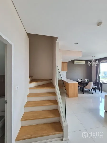 公寓 出售在Ratchathewi, Bangkok - 木质楼梯配玻璃扶手通往上层，旁为开放式厨房