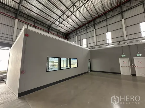 工厂 出租在Chon Buri - 厂内办公区，带窗户、紧急出口门及消防设施。
