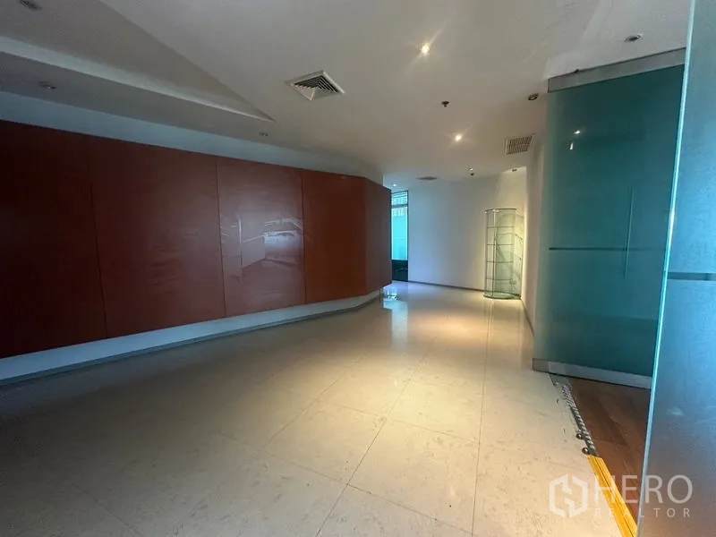 办公空间 出租在Khlong Toei, Bangkok - 宽敞走廊，弧形木质装饰墙与磨砂玻璃面板。