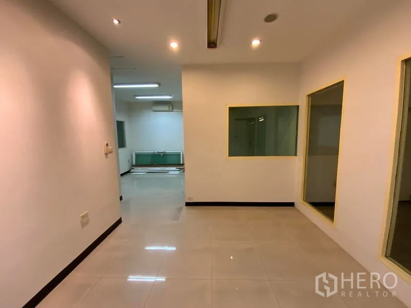 办公空间 出租在Watthana, Bangkok - 走廊式工作区，瓷砖地、室内窗与筒灯，可见水槽区