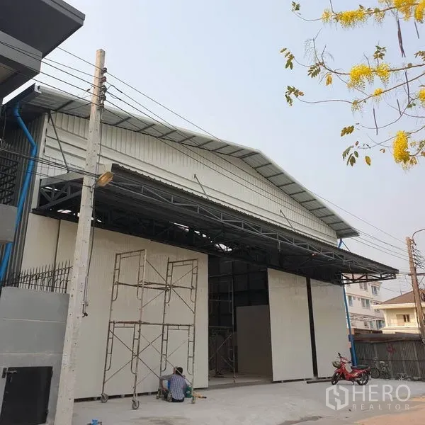 Warehouse for rent in Khlong Toei, Bangkok - Modern steel‑clad warehouse exterior with wide sliding doors and covered loading canopy.