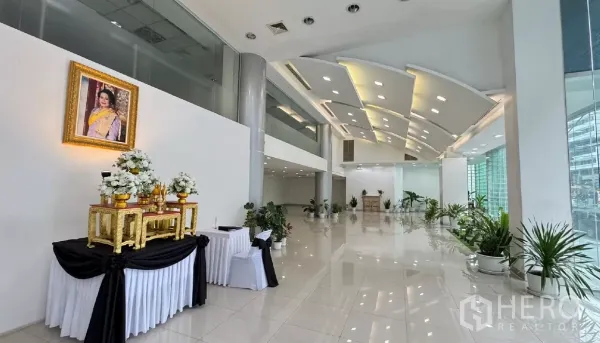 Retail Space for rent in Huai Khwang, Bangkok - Expansive lobby-style retail area with modern lighting, glass facade and a decorative display against a white wall.