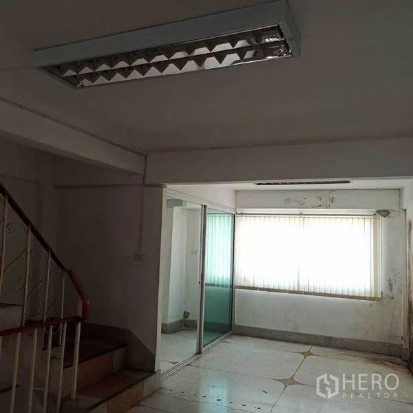 Shophouse for rent in Khlong Toei, Bangkok - Lower level with staircase, glass sliding partition and window blinds.