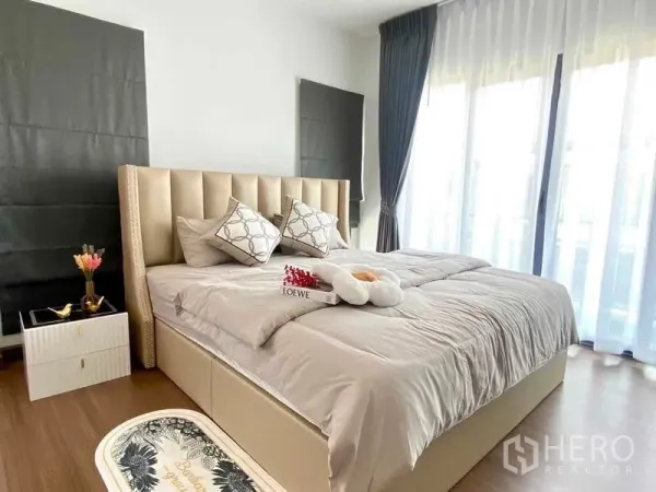 独立式住宅 出租或出售在Bang Phli, Samut Prakan - 明亮的主卧，软包床、木地板与落地纱帘。