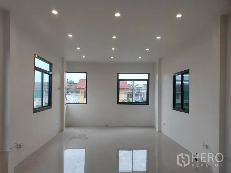 Warehouse for rent or sale in Lam Luk Ka, Pathum Thani - Bright upper-floor office with recessed LED lighting and windows on three sides.