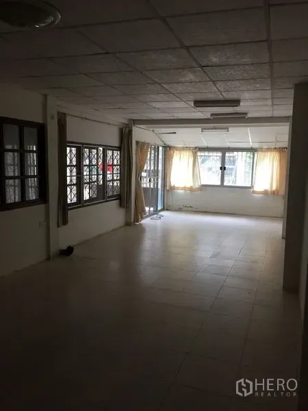 联排别墅 出租在Khlong Toei, Bangkok - 修长的瓷砖客厅，配窗户与窗帘，采光充足