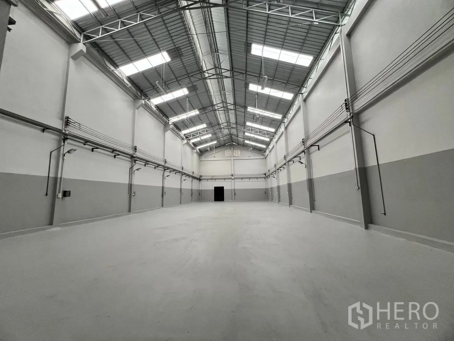 Factory for rent in Bang Bua Thong, Nonthaburi - Large open production hall with polished floor and overhead lighting.
