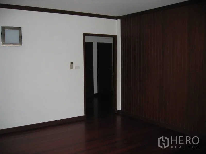 独立式住宅 出租在Watthana, Bangkok - 房间设深色木饰面墙板与走廊门口。