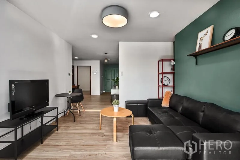Condominium for rent in Watthana, Bangkok - Spacious living area with TV console, round light fixture and balcony view.