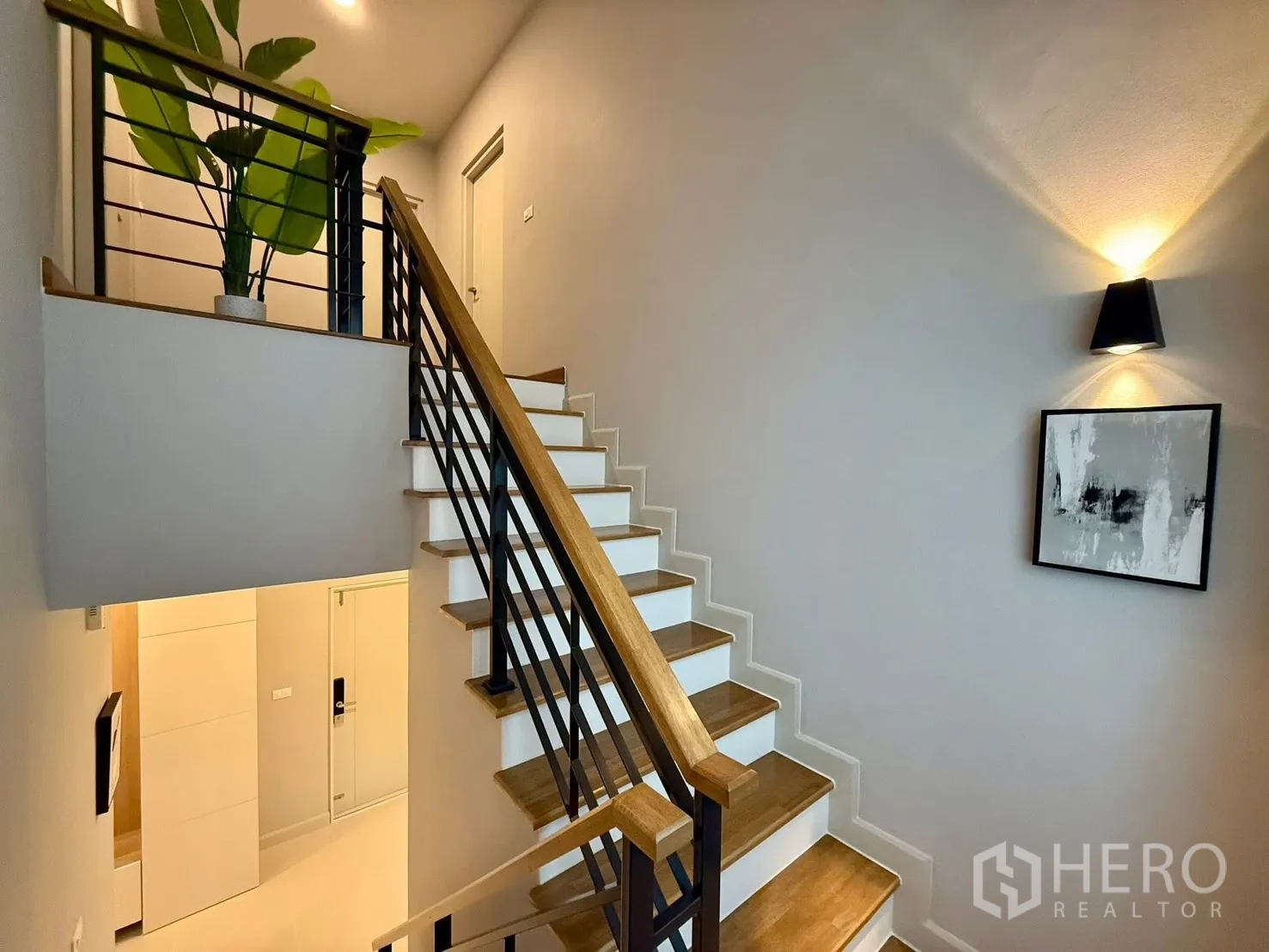 Detached House for rent in Bang Phli, Samut Prakan - Staircase with wooden treads, black metal railing and potted plant.