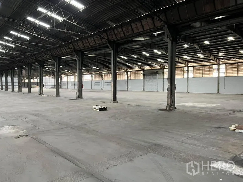 Warehouse for rent in Bang Pa-in, Phra Nakhon Si Ayutthaya - Row of steel columns in the warehouse with concrete floor and louvered wall panels.