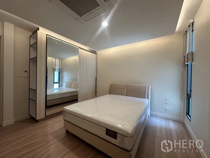 联排别墅 出租在Watthana, Bangkok - 卧室配镜面衣柜与采光窗，灯光柔和