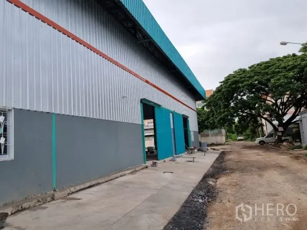 คลังสินค้า ให้เช่าในSaphan Sung, Bangkok - ด้านข้างตัวอาคารเมทัลชีท ประตูบานเลื่อนขนาดใหญ่ ทางสัญจรติดแนวต้นไม้