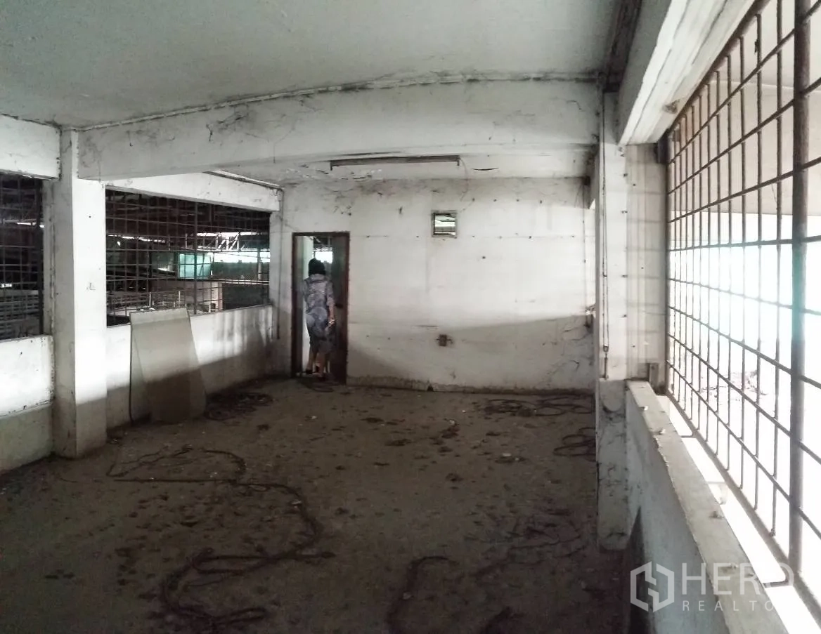 Office Space for rent in Don Mueang, Bangkok - Compact unfinished office room with barred windows and natural light through side openings.