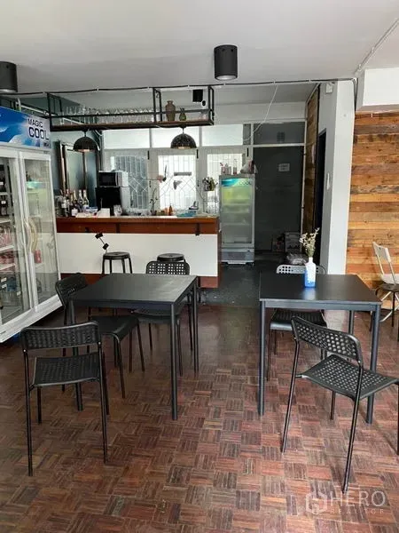 带办公室的家 出租在Pathum Wan, Bangkok - 咖啡风吧台，吊灯、挂杯架与前方黑色餐桌。