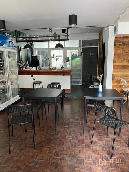 带办公室的家 出租在Pathum Wan, Bangkok - 咖啡风吧台，吊灯、挂杯架与前方黑色餐桌。
