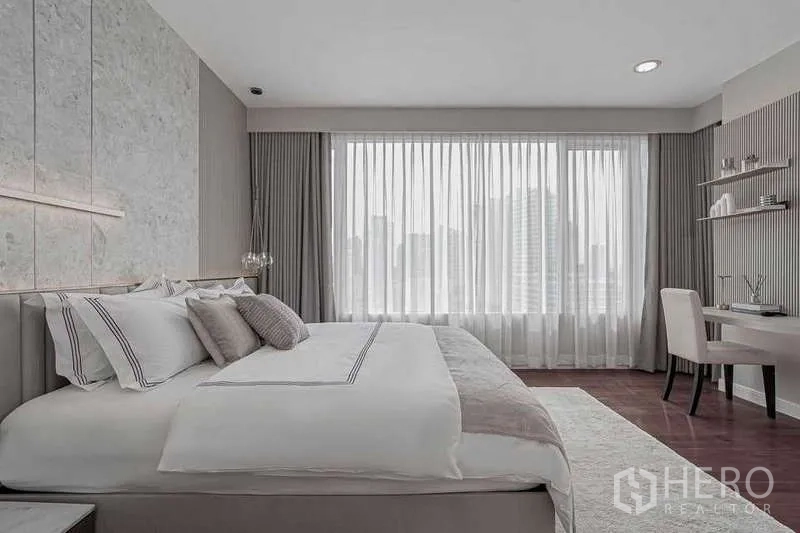 公寓 出租或出售在Watthana, Bangkok - 卧室带工作区，大窗与中性柔和配色。