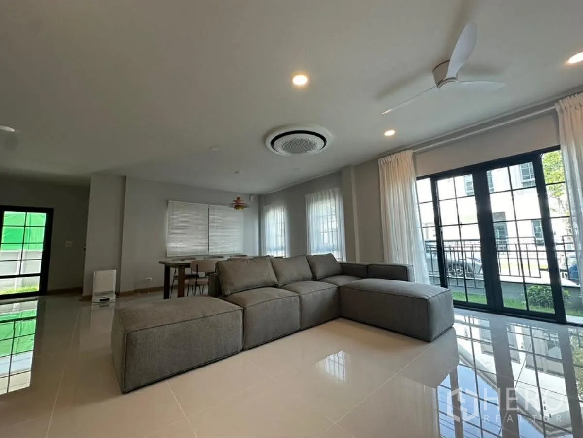 独栋房屋 for rent in Bang Phli, Samut Prakan - 宽敞客厅设大转角沙发与推拉玻璃门。