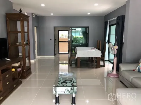 Detached House for rent in Bang Kapi, Bangkok - Open-plan living and dining area with glossy tile floors, recessed lights and sliding doors.