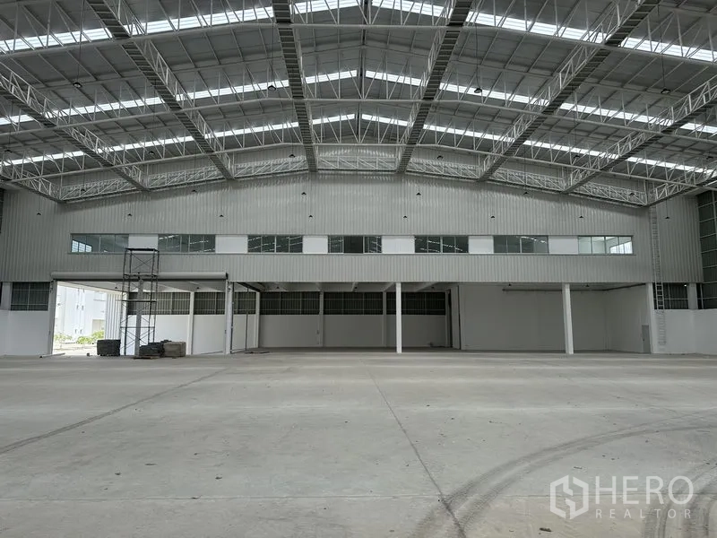 Factory for rent in Pathum Thani - Close view of the warehouse mezzanine facade with windows and roller shutters.