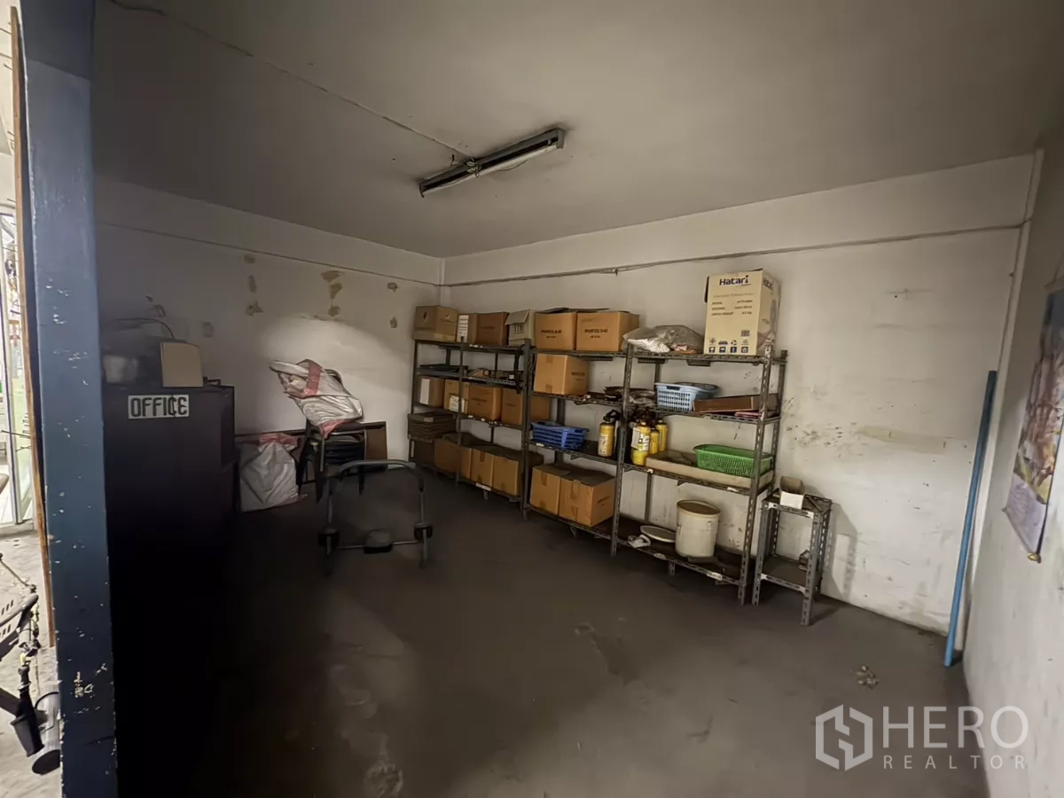 Warehouse for rent in Khlong Toei, Bangkok - Compact storeroom fitted with metal shelving and boxes.