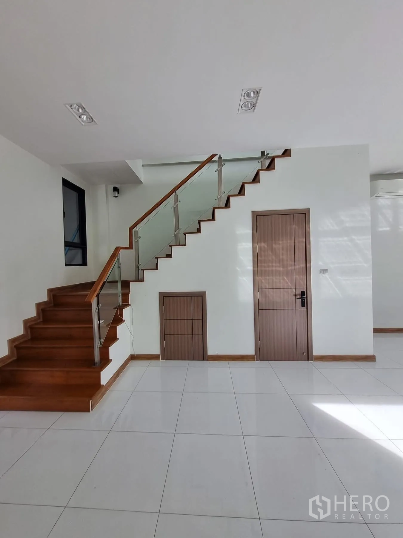 Home Office for rent in Khlong Toei, Bangkok - Staircase wall featuring storage doors beneath the steps.