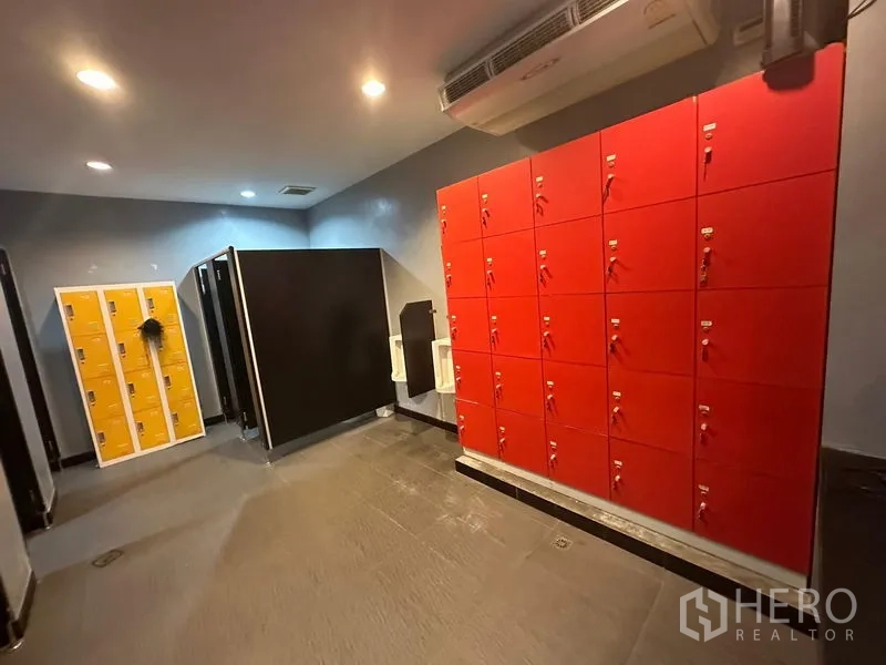 货栈 出租在Khlong Toei, Bangkok - 更衣室，红色储物柜、地砖与顶灯。