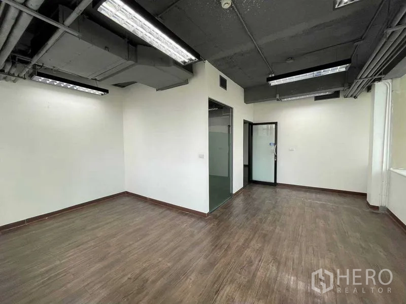 Office Space for rent in Ratchathewi, Bangkok - Private office room with glass door, exposed ceiling and wood-look floor.