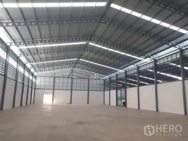 货栈 出租在Bang Phli, Samut Prakan - 宽敞高挑的仓库内部，钢结构桁架屋顶、天窗与抛光混凝土地面。
