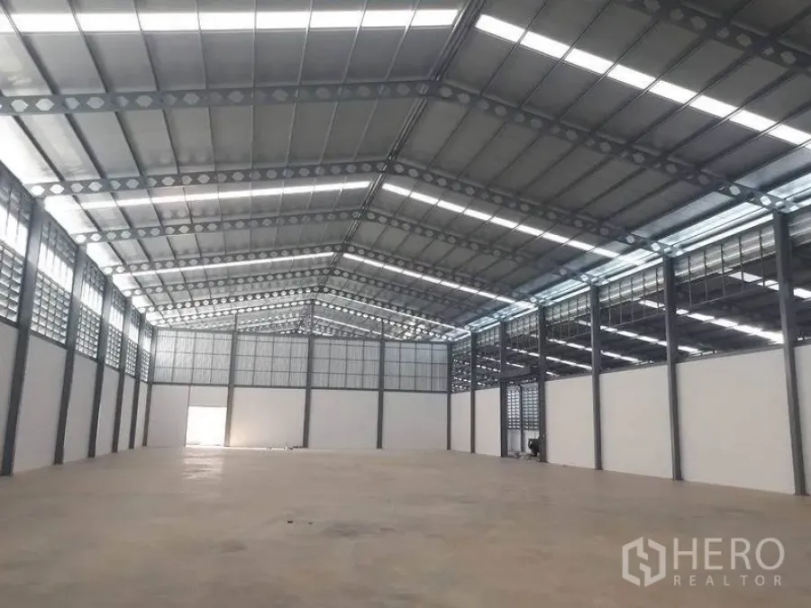 Warehouse for rent in Bang Phli, Samut Prakan - Spacious high-clear warehouse interior with steel truss roof, skylights and polished concrete floor.