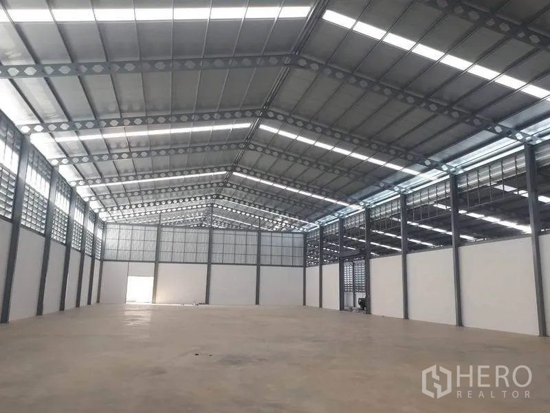 Warehouse for rent in Bang Phli, Samut Prakan - Spacious high-clear warehouse interior with steel truss roof, skylights and polished concrete floor.