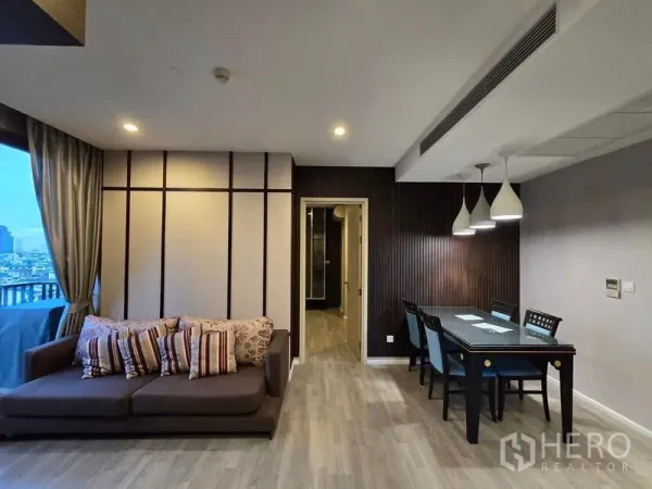 Condominium for rent - Living room with sofa and dining table under pendant lighting.