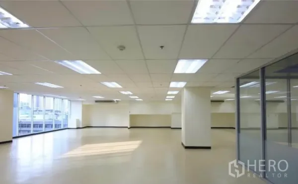 办公空间 出租在Watthana, Bangkok - 宽敞的开放式办公室，网格吊顶灯、立柱与大窗，享城市景观。