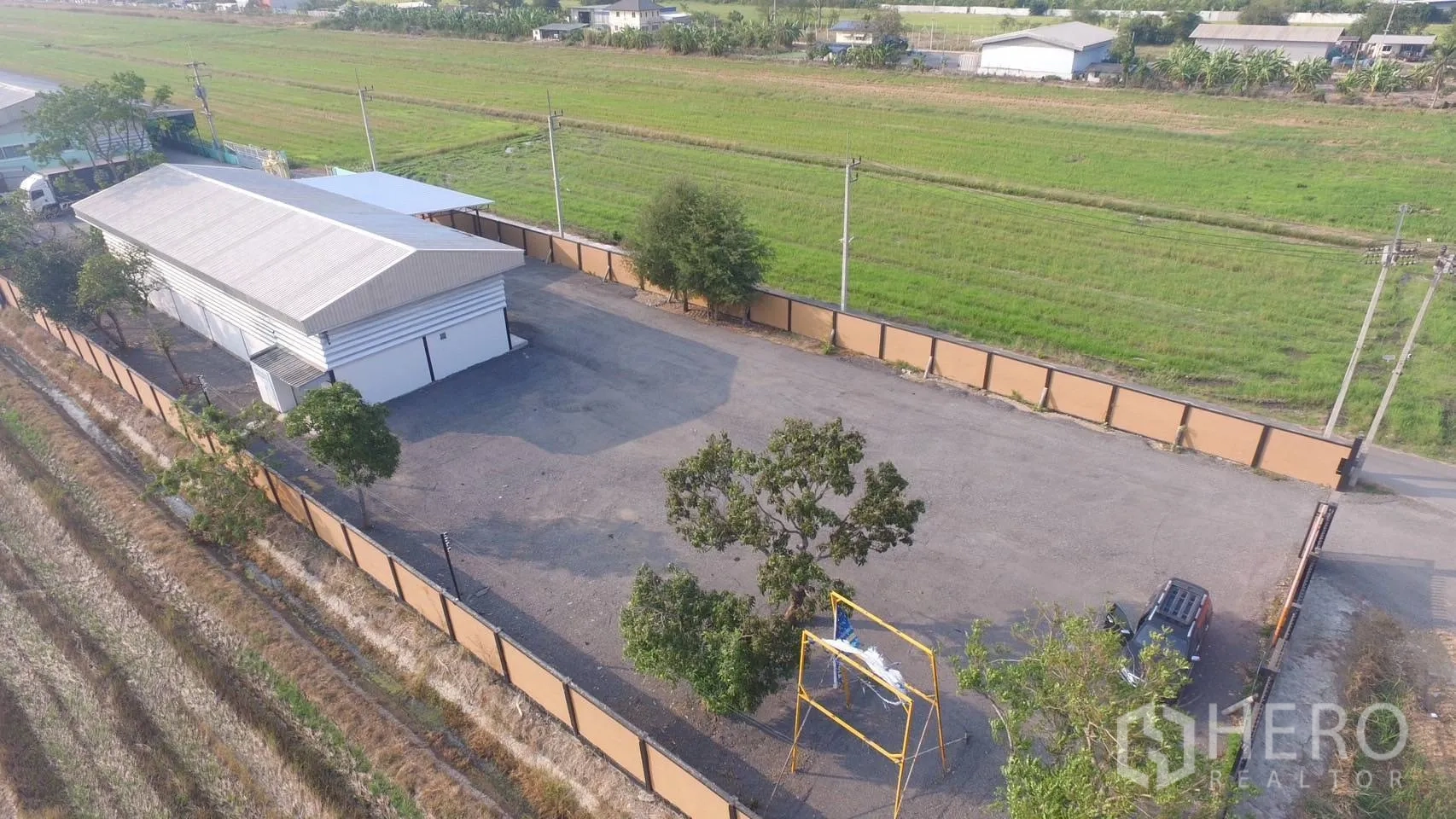 โกดัง for sale in Lam Luk Ka, Pathum Thani - ภาพมุมสูงของโกดังภายในรั้ว พร้อมลานเปล่าพื้นแข็งสำหรับจอดรถ