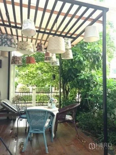 บ้าน ให้เช่าหรือขายในPrawet, Bangkok - ระเบียงนั่งเล่นมีเพิงโปร่ง แขวนโคมไฟ พร้อมชุดโต๊ะกลางสวนของบ้านเดี่ยว