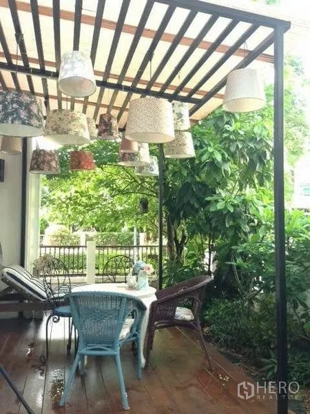 บ้าน ให้เช่าหรือขายในPrawet, Bangkok - ระเบียงนั่งเล่นมีเพิงโปร่ง แขวนโคมไฟ พร้อมชุดโต๊ะกลางสวนของบ้านเดี่ยว