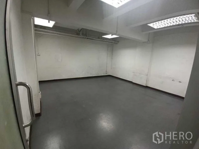 Office Space for rent in Ratchathewi, Bangkok - Empty workspace with gray vinyl flooring, white walls and bright ceiling lights.