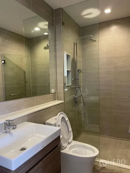 Condominium for rent in Bang Kho Laem, Bangkok - Second bathroom with glass shower, modern fixtures, and neutral tiles.