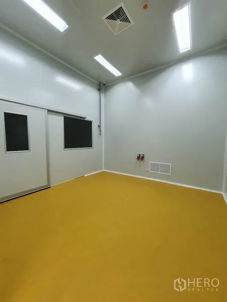 工厂 出售在Lam Luk Ka, Pathum Thani - 洁净生产间，白色墙面与黄色环氧地坪，顶置照明与通风口。