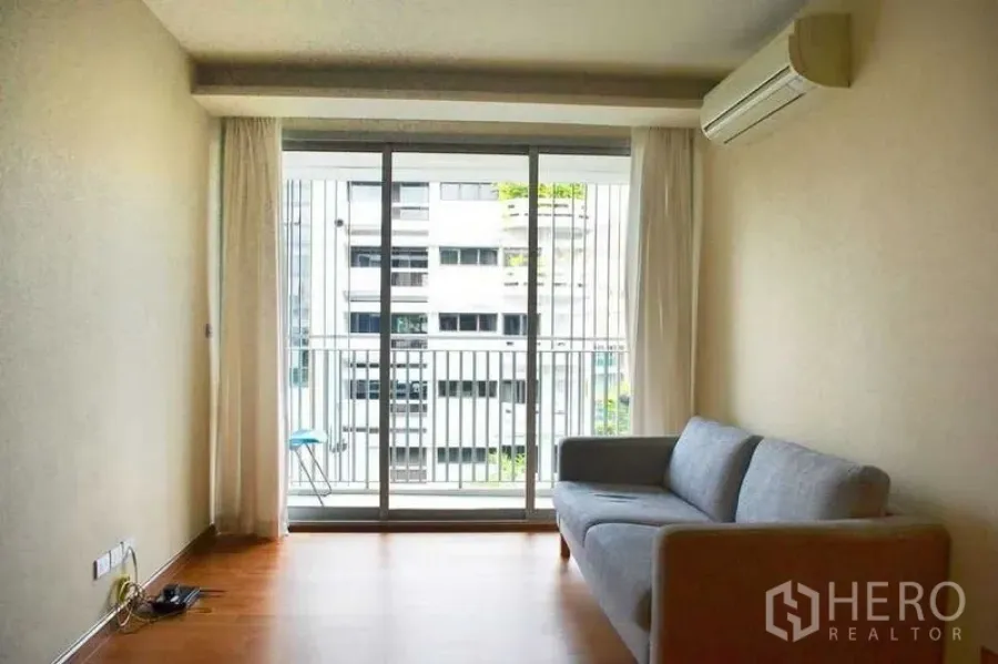 公寓 出租在Watthana, Bangkok - 极简客厅，木地板，带阳台与城市景观。