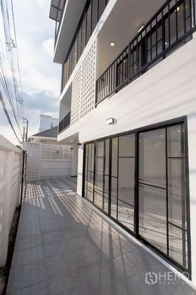 带办公室的家 出售在Huai Khwang, Bangkok - 建筑侧廊道，设玻璃推拉门与上层阳台。