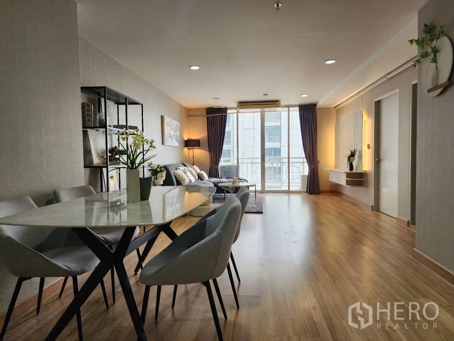 公寓 for rent in Watthana, Bangkok - 餐区设椭圆形大理石餐桌与四把椅子，邻接客厅。