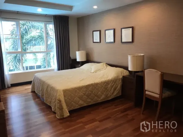 公寓 出租在Watthana, Bangkok - 宽敞主卧，木地板，大床、书桌与大窗户。