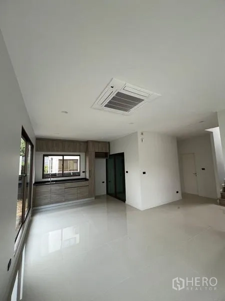 Detached House for sale in Bang Kapi, Bangkok - Kitchen and dining zone with ceiling cassette AC and sliding doors to the patio.