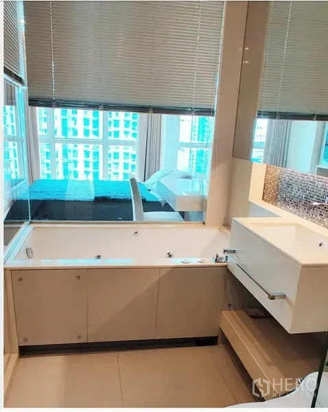 公寓 出租在Ratchathewi, Bangkok - 现代浴室设浴缸与大镜面，玻璃隔断与卧室相连。