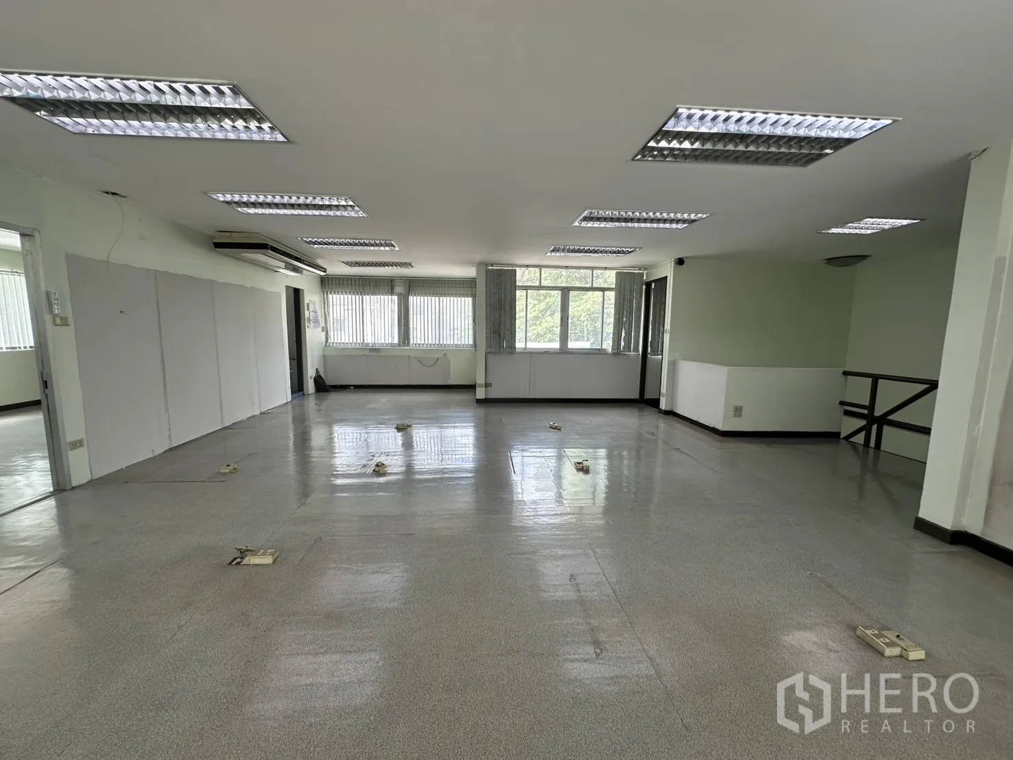 Retail Space for rent in Watthana, Bangkok - Open office showing grey flooring, ceiling lights and corner windows.