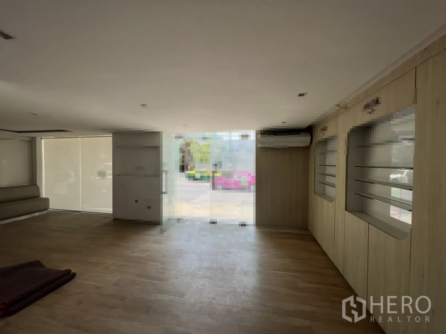 Shophouse for rent or sale in Watthana, Bangkok - Showroom view toward the entrance and street-facing glass wall.