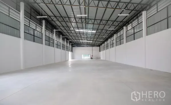 工厂 出租或出售在Bang Len, Nakhon Pathom - 宽敞仓库内部，高钢结构屋顶与抛光混凝土地面。