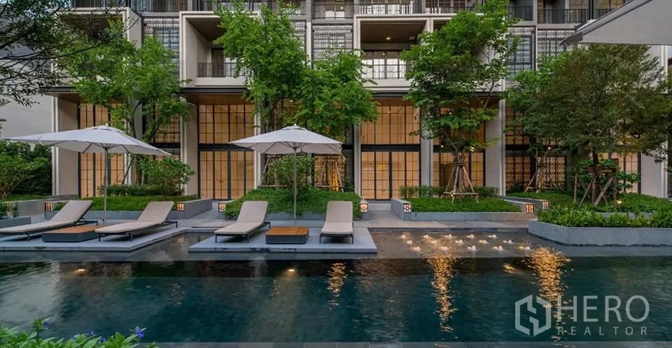 ทาวน์เฮาส์ for rent or sale in Watthana, Bangkok - สระว่ายน้ำกลางแจ้งพร้อมเตียงอาบแดดท่ามกลางสวนสีเขียว